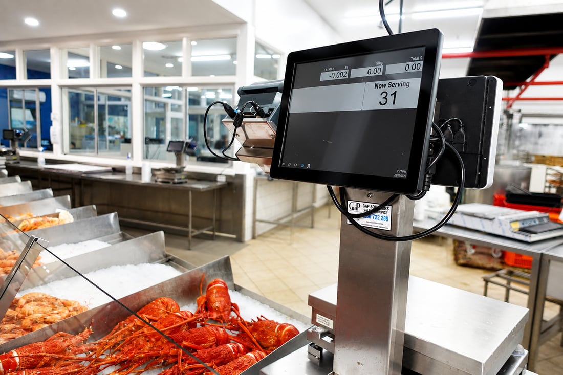 Customer-facing Ezi Scale display at a seafood counter showing price and product